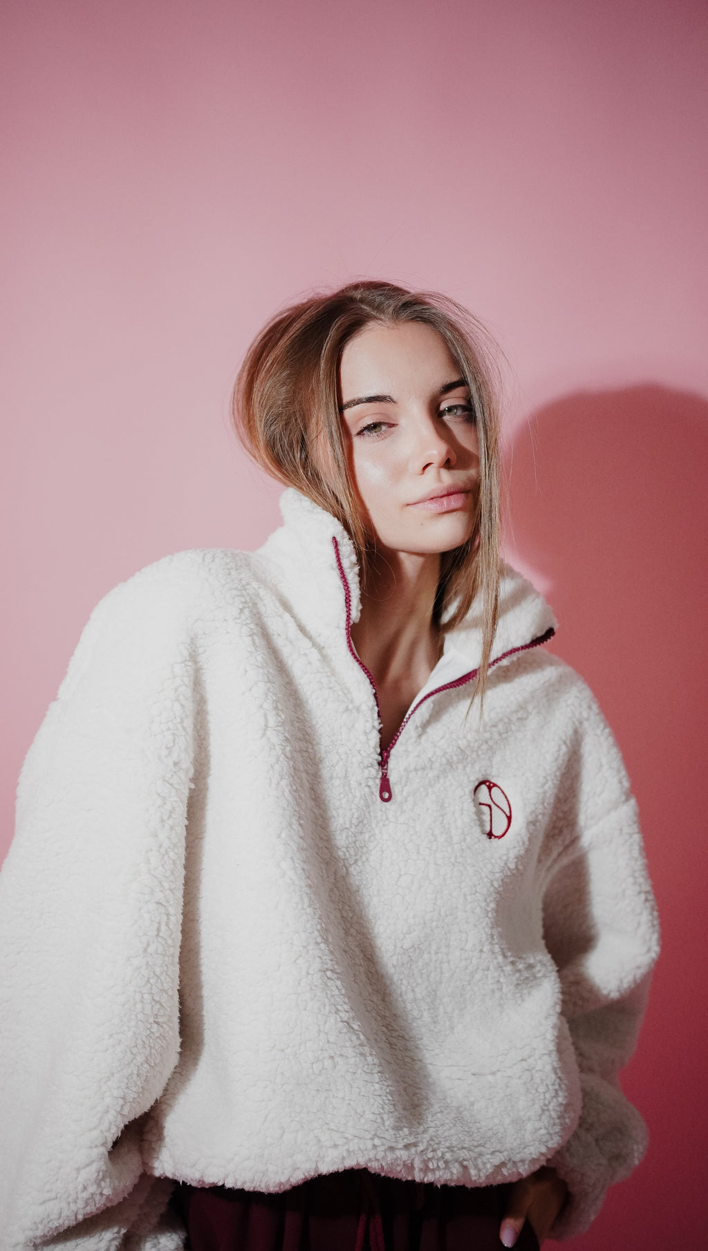 Detail view of quarter-zip fleece anorak in Cloud Dancer — showing embroidered GIS chest logo and zipper closure