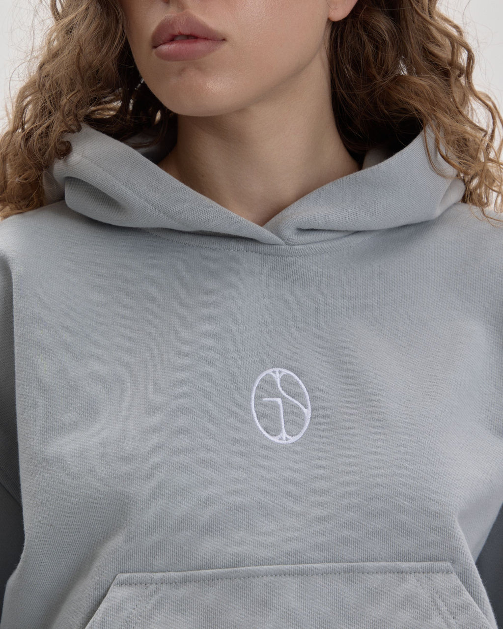 Grown In Silence cropped mini hoodie in Cloud Metallic, embroidered GIS chest logo close-up