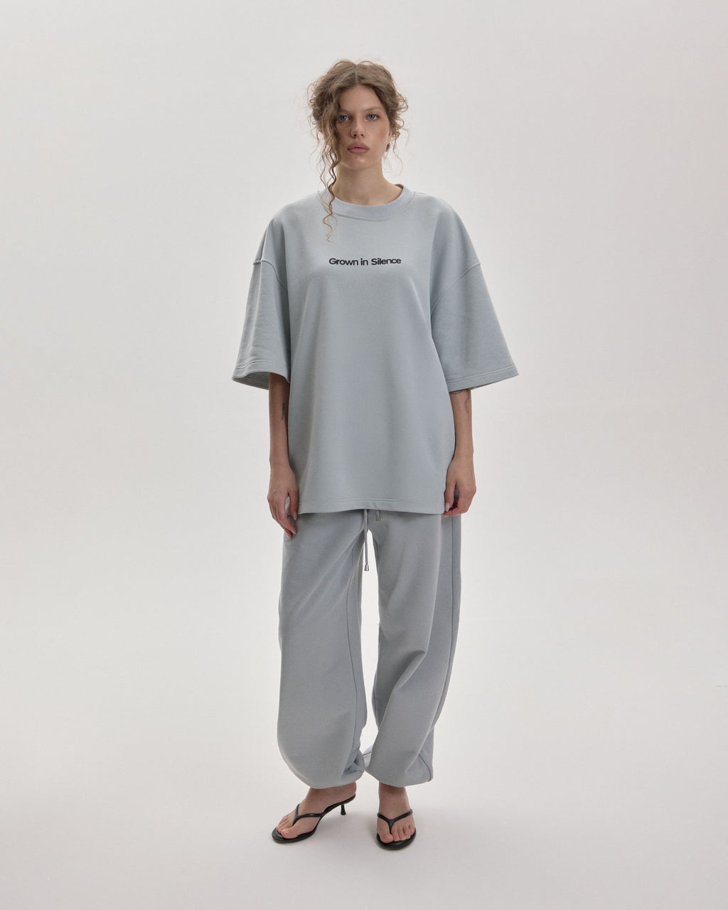 Grown In Silence oversized unisex tee in Cloud Metallic, front view on female model