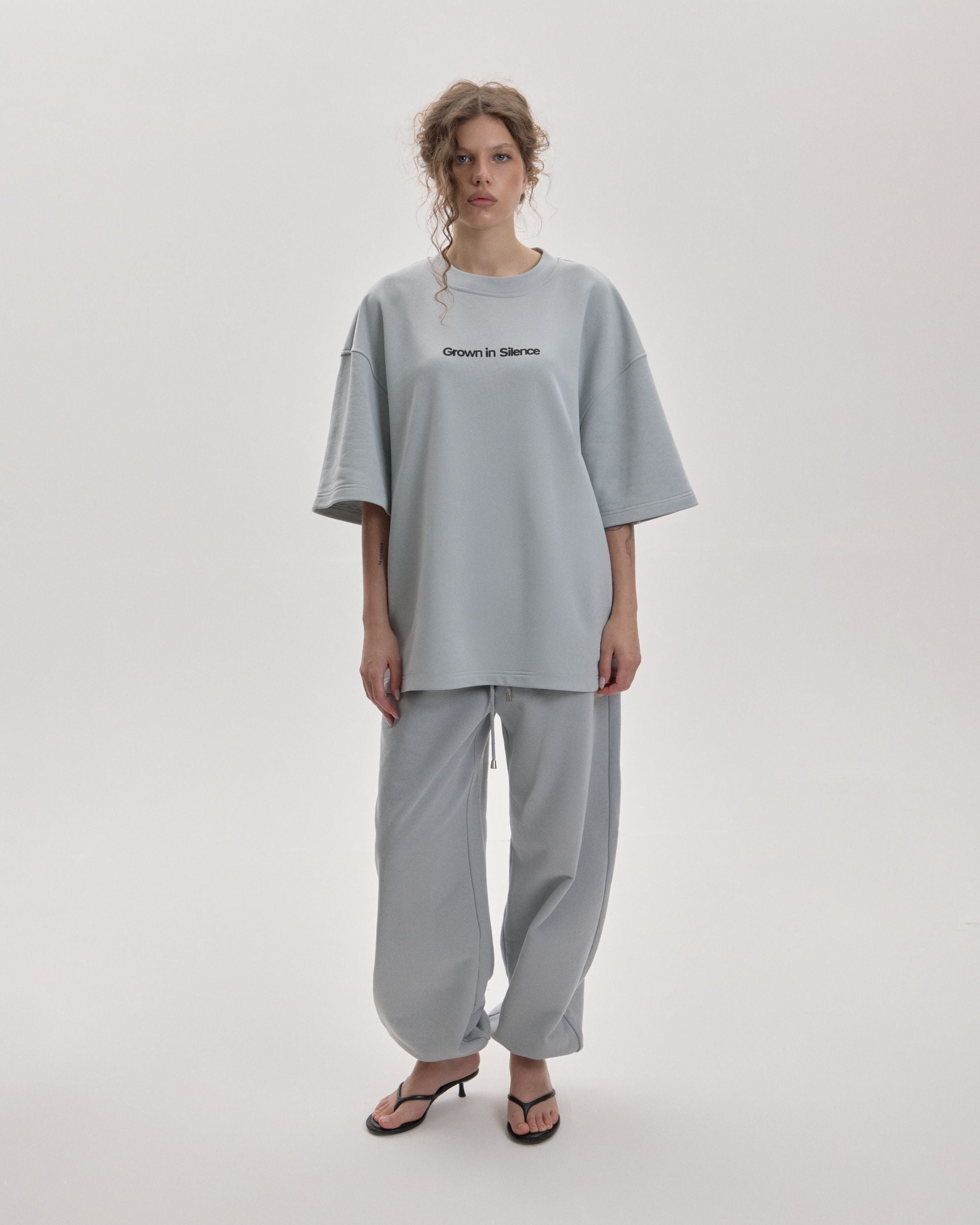 Grown In Silence oversized unisex tee in Cloud Metallic, front view on female model