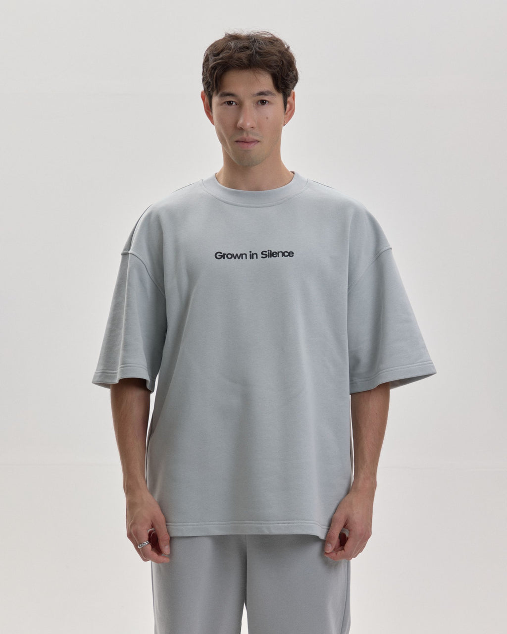 Grown In Silence oversized unisex tee in Cloud Metallic, full length front view on male model