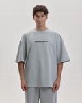Grown In Silence oversized unisex tee in Cloud Metallic, full length front view on male model