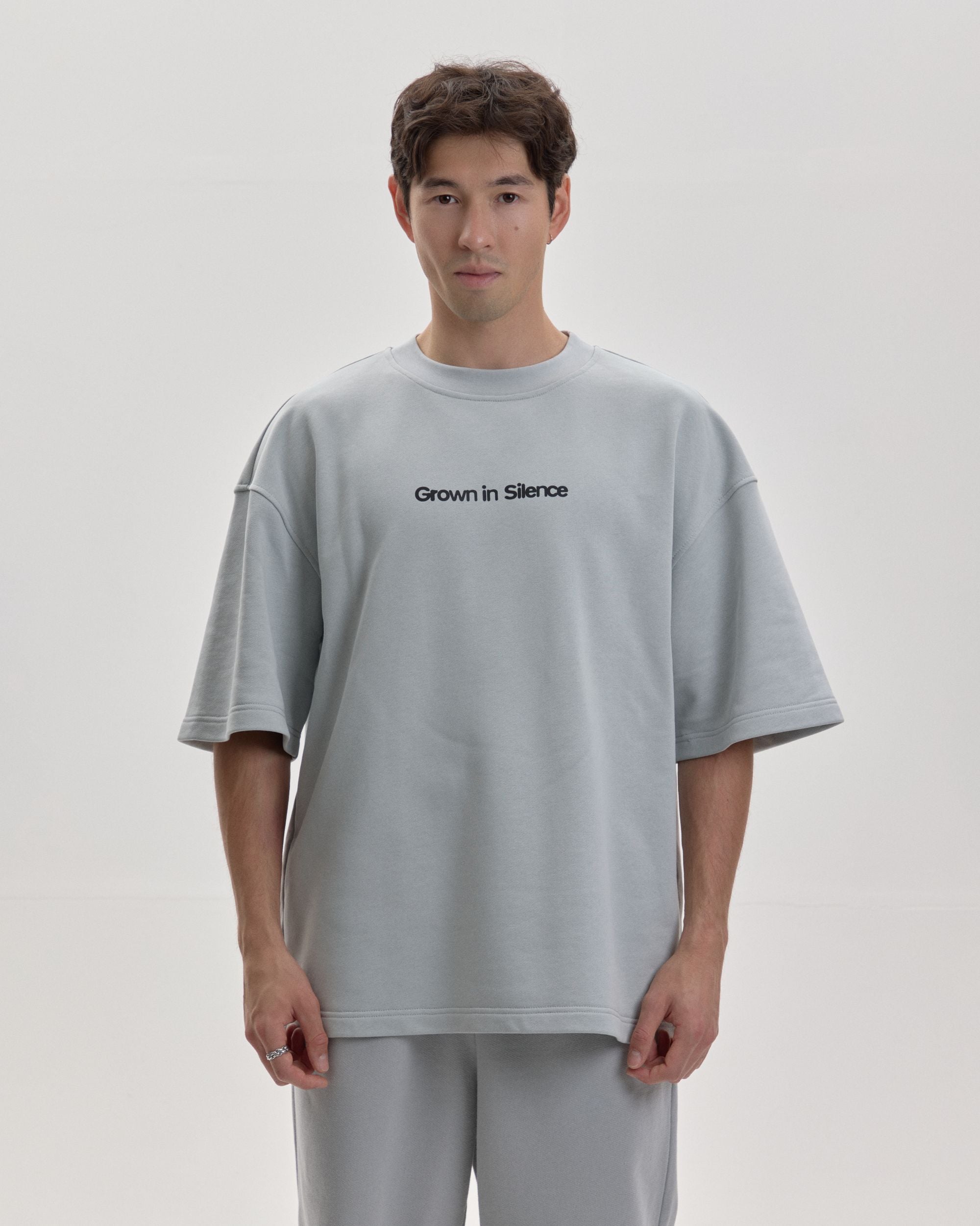 Grown In Silence oversized unisex tee in Cloud Metallic, full length front view on male model