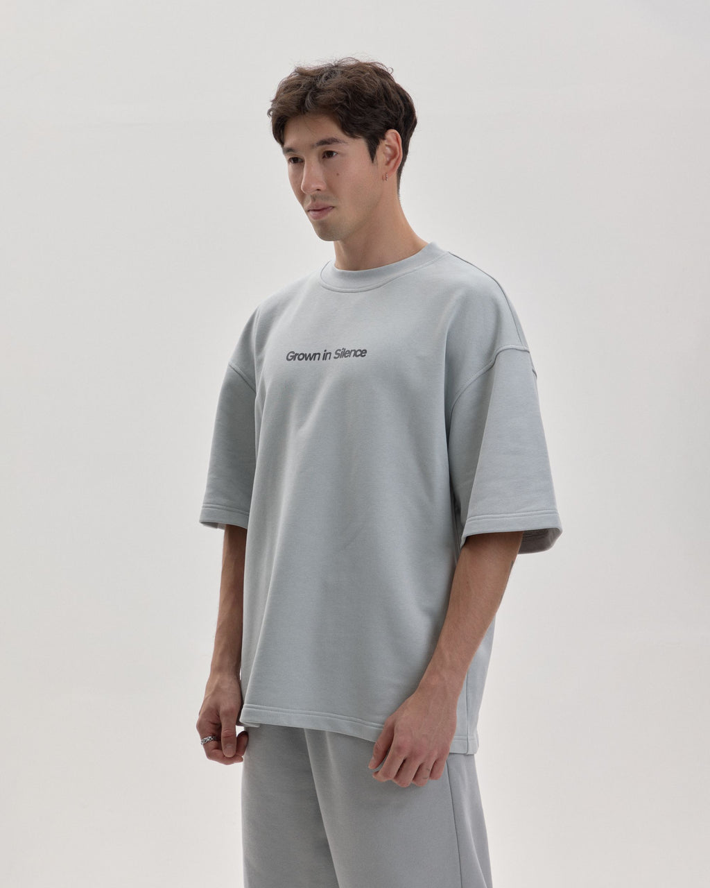 Grown In Silence oversized unisex tee in Cloud Metallic, front view on male model