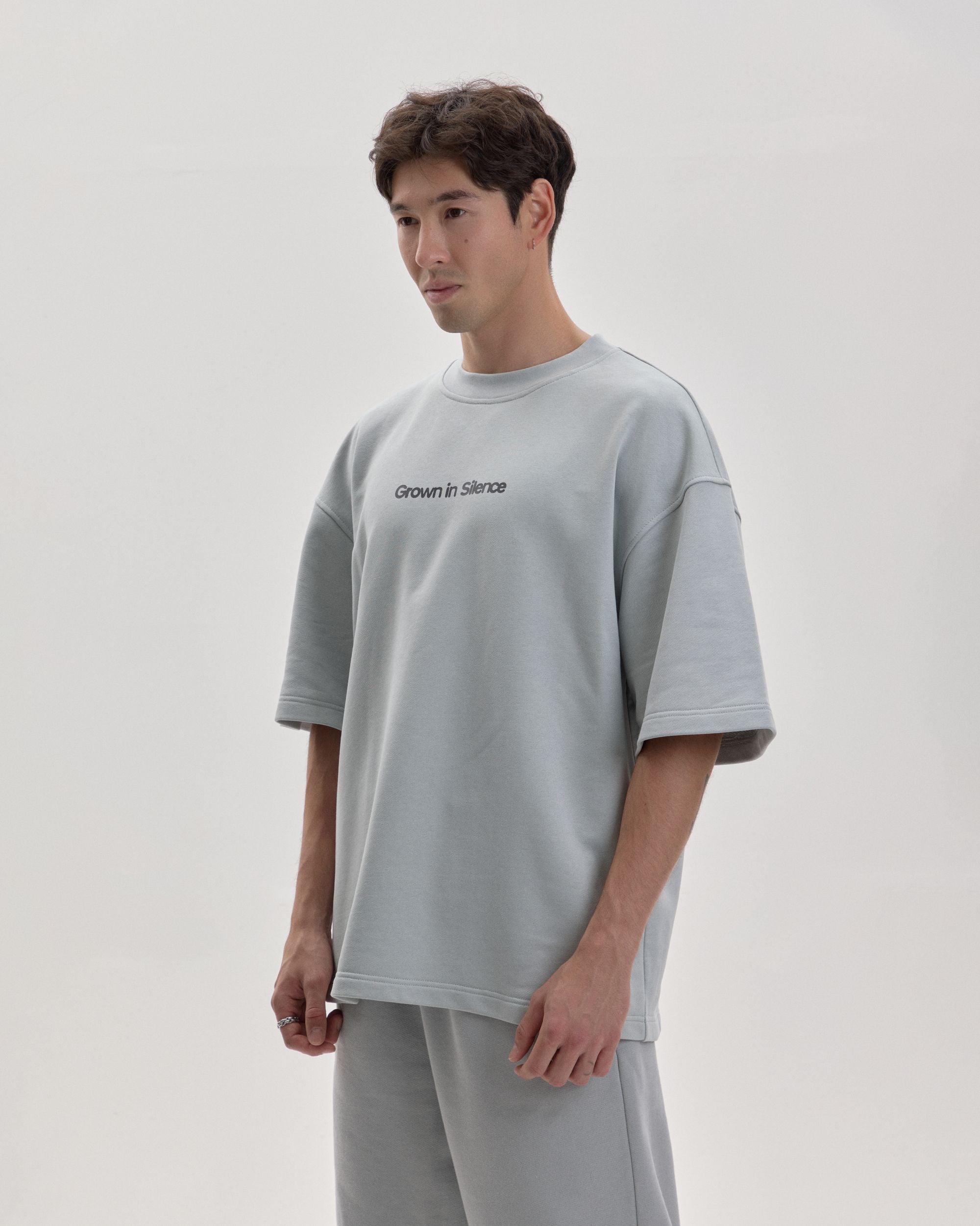 Grown In Silence oversized unisex tee in Cloud Metallic, front view on male model