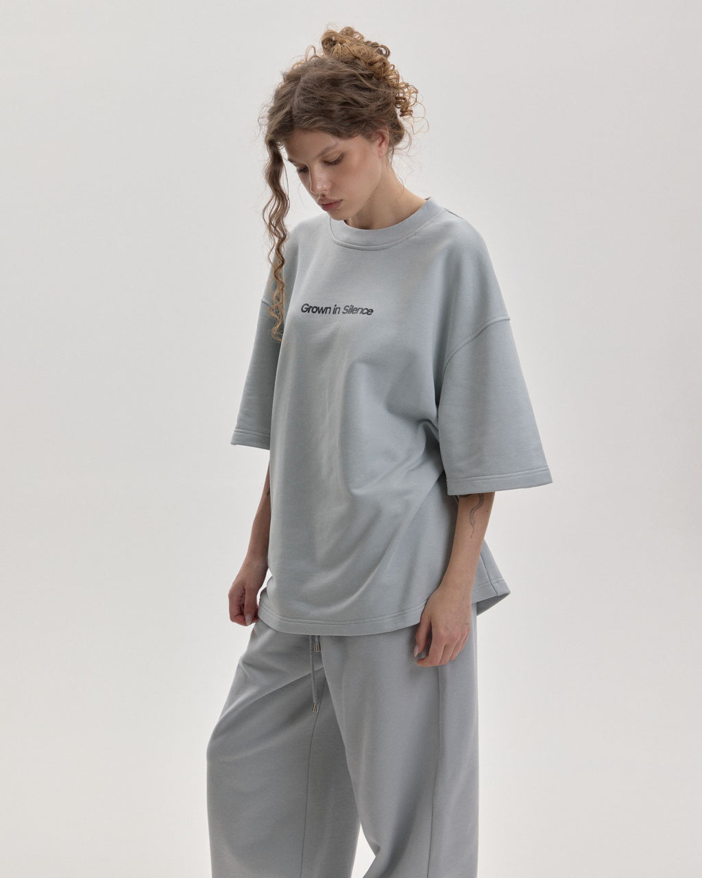 Grown In Silence oversized unisex tee in Cloud Metallic, side view on female model