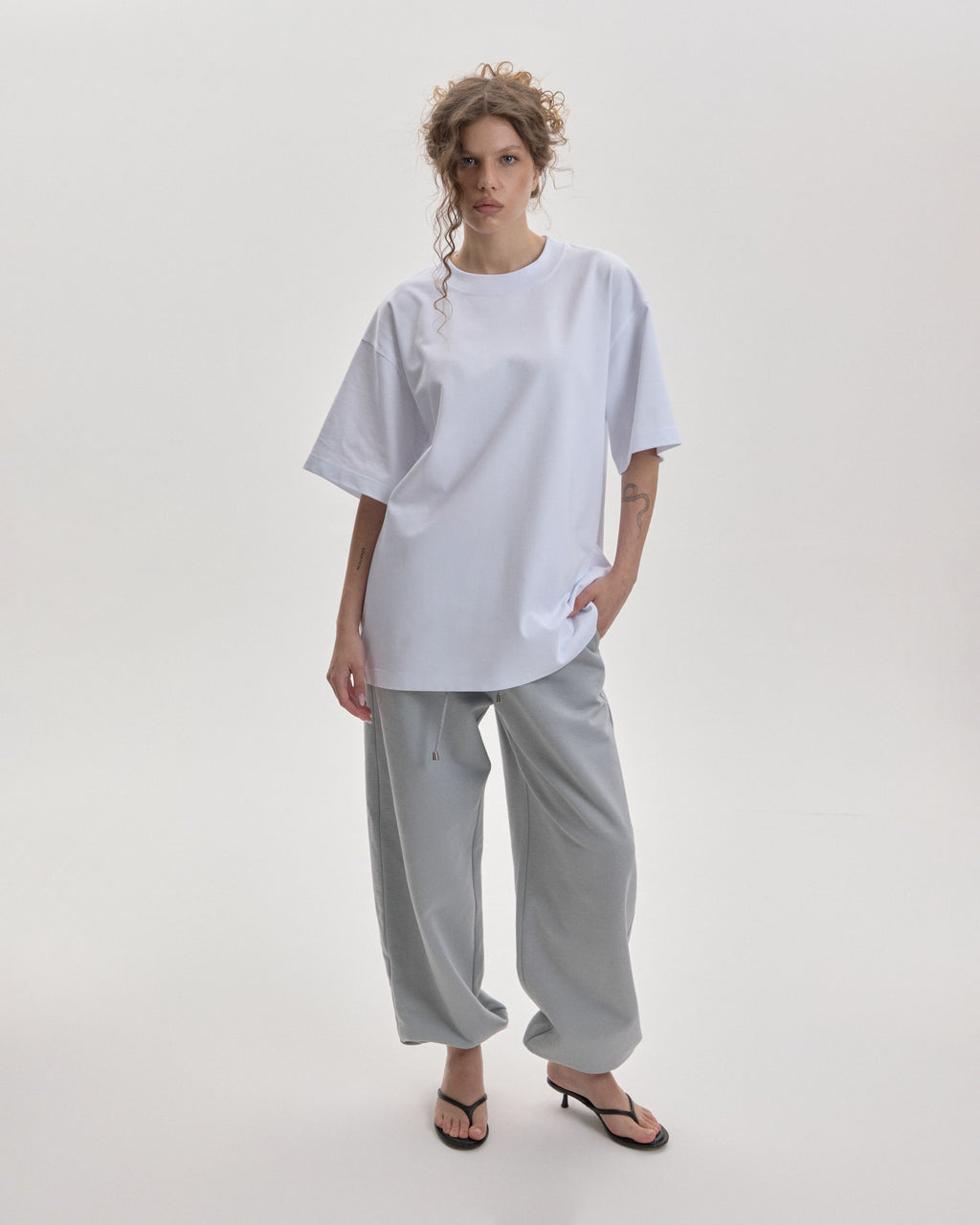 Grown In Silence oversized unisex tee in Raw White, front view on female model