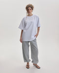 Grown In Silence oversized unisex tee in Raw White, front view on female model
