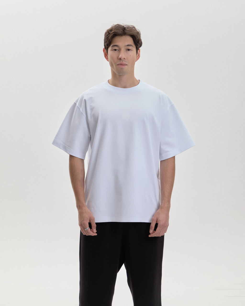 Grown In Silence oversized unisex tee in Raw White, front view on male model
